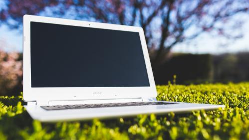 Laptop with blank screen on grass