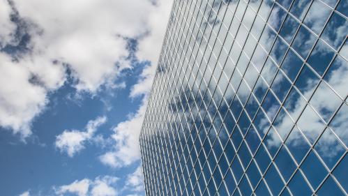 Glass building against cloudy blue sky