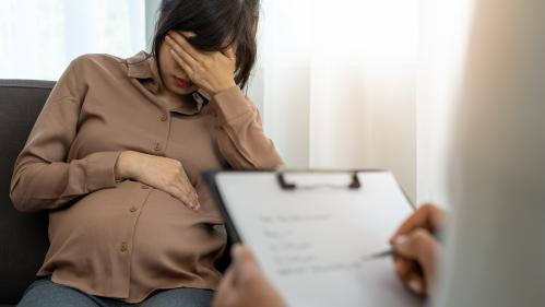 Pregnant woman sitting in front of a doctor taking notes