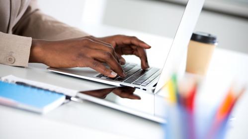 Close-up of hands of businesswoman typing on a laptop.