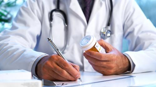 A doctor in a white lab coat writing down a prescription