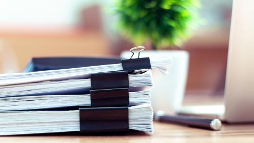 Stack of documents placed on a business desk in a business office