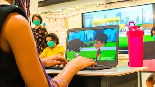 Child learning on a computer in a classroom