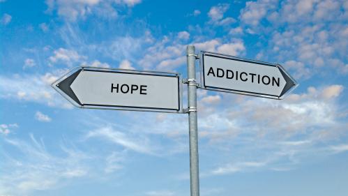 Road signs pointing in different directions with the words "hope" and "addiction"