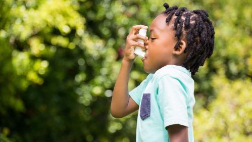 boy uses asthma inhaler