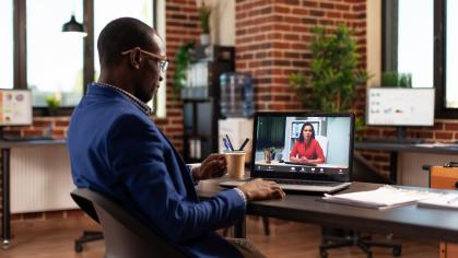 Person using online video call to talk to another person on laptop for meeting/planning.