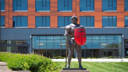 An image of the Scarlet Knight statue in front of a building
