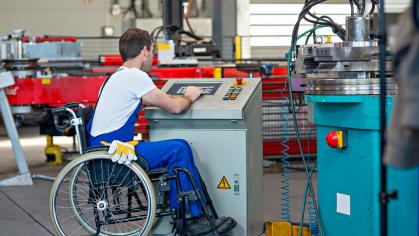 Disabled worker in wheelchair in factory 