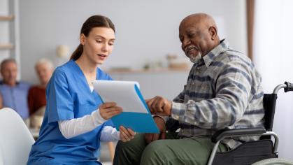 A young nurse helping senior Black man with questionnaire