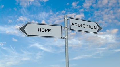Road signs pointing in different directions with the words "hope" and "addiction"