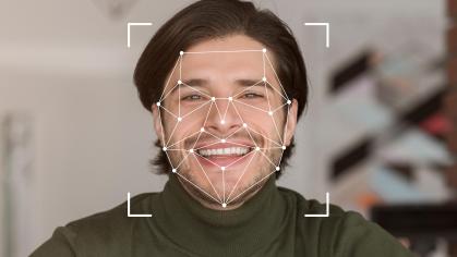 A smiling individual is displayed within a digital facial recognition framework, showcasing advanced identification technology.