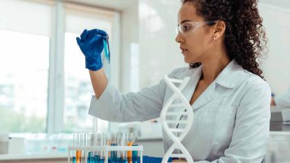 Woman in a lab coast holding a test tube in a lab setting