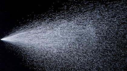 Water being sprayed over a black background