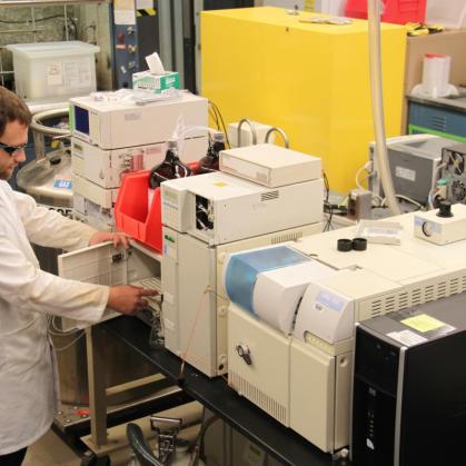 Staff member in lab coat using equipment
