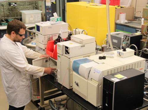 Staff member in lab coat using equipment