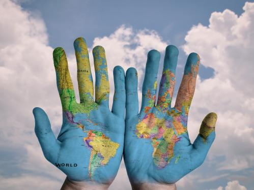 Hands with map of the world painted on