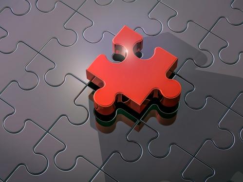 Dark metallic puzzle with one raised red piece in the center