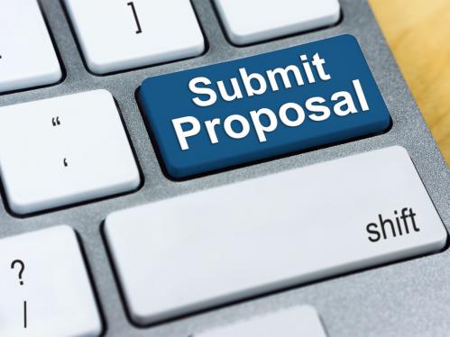 Partial view of laptop keyboard with blue submit proposal button