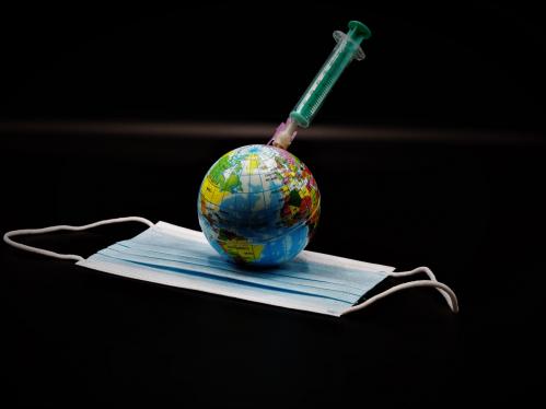 A small globe on top of a surgical mask with a needle injected into globe