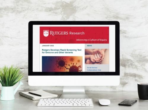 Computer with monitor featuring Rutgers Research newsletter on screen