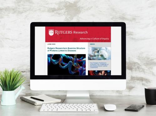 Computer with monitor featuring Rutgers Research newsletter on screen