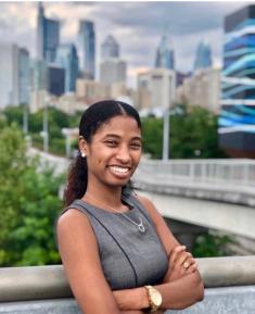 Photo of Dr. Kayla Preito-Hodge with cityscape in background