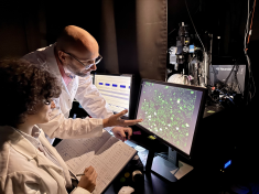 Image of Rutgers professor Pierre-Olivier Polack with a student looking at a computer screen